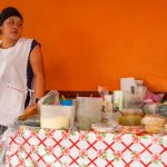 Emprendedora hispana atendiendo a un cliente en su negocio