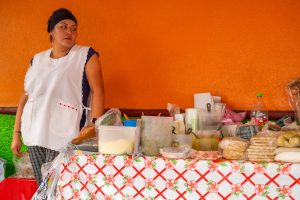 Emprendedora hispana atendiendo a un cliente en su negocio