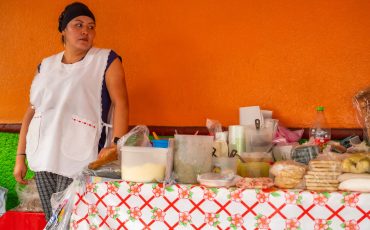 Emprendedora hispana atendiendo a un cliente en su negocio